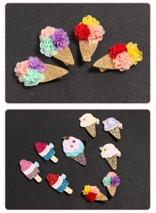 Dettaglio di fermagli per capelli a forma di gelato glitter con petali colorati