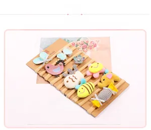 Close-up of 10-piece baby hairband set featuring plush animals and knitted flowers on card