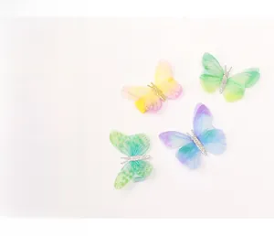 Détail de quatre pinces à cheveux papillon en tulle coloré avec paillettes et métal