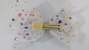 Detail showing the fabric wrapped crocodile clip and colorful stars on mesh hair bow