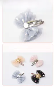 Detailed view of polka dot mesh bow hairpins with glitter stars and metal BB clips