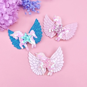 Detalle de pinzas para el pelo con alas de unicornio con purpurina en azul, rosa y blanco