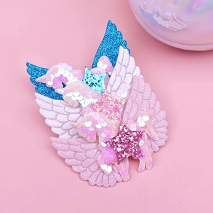 Detalle de ala de unicornio y estrella con lentejuelas rosas y textura brillante