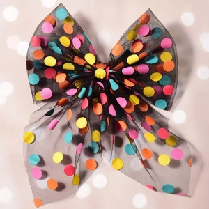 Detail of a black mesh hair bow clip featuring colorful sparkling polka dots for girls