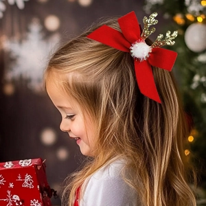 Détail de la barrette en velours rouge avec bois dorés pailletés et pompon blanc