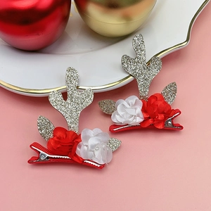 Détail de pinces à cheveux bois de renne de Noël avec paillettes et fleurs en tissu