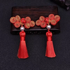 Detailansicht der roten chinesischen Stoffknoten mit Perlen und langen Seidenquasten
