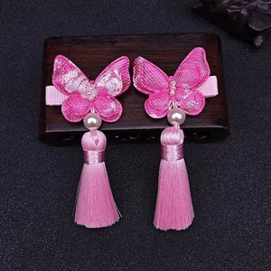 Detail von rosa bestickten Schmetterlings-Haarspangen mit Perlen und langen Seidenquasten