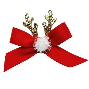 Détail d'une pince à cheveux de Noël avec nœud en velours rouge et bois dorés brillants