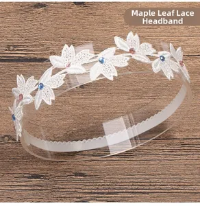 Close-up of white lace headband with maple leaf embroidery and colorful rhinestones