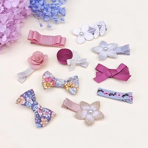 Detail view of a 10-piece floral bow hair clip set with lace and pearl accents