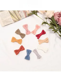 Detail view showing a set of 10 linen bow hair clips in various Morandi colors for babies