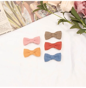Detailed set of 5 colorful corduroy bow hair clips for infants in vibrant pastel shades