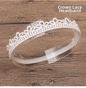 Detail of white lace crown headband with rhinestones and pearls on a wooden surface