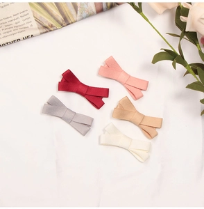 Flat lay of five cotton linen bow hair clips in red, pink, gray, khaki, and beige colors