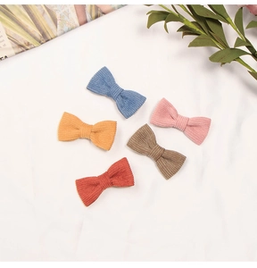 Detailed macro view of five colorful corduroy bow hair clips with soft ribbed texture