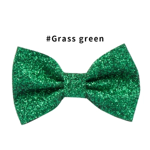 Dettaglio del fiocco per capelli verde erba glitterato con texture di paillettes lucide