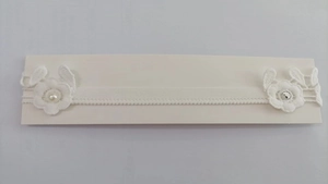 Detailed macro of white lace headband with elegant pearls and sparkling rhinestones