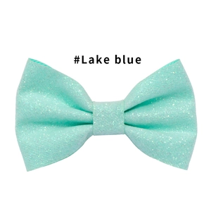 Dettaglio del fermaglio a fiocco blu lago con glitter e texture scintillante per bimbe