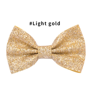 Dettaglio di un fermaglio per capelli con glitter oro chiaro e classico design a doppio fiocco
