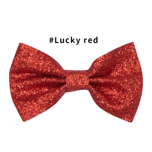 Dettaglio del fermaglio per capelli a fiocco rosso glitterato con finitura di paillettes