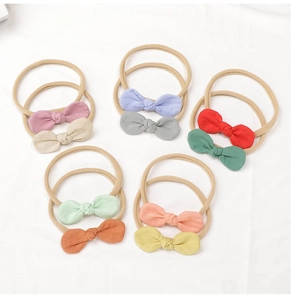 Vue à plat de 10 bandeaux bébé en lin avec nœuds colorés et nylon extensible