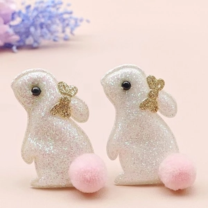 Détail de barrettes à cheveux lapin à paillettes avec nœud doré et pompon rose doux