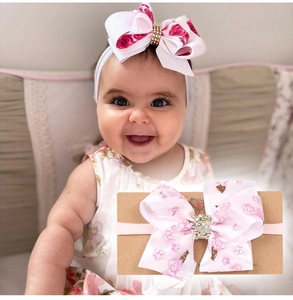 Détail de bandeaux bébé avec grands nœuds floraux et centres ornés de strass brillants