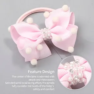 Bandeau bébé rose avec nœud en ruban, pompons et décorations en perles et strass