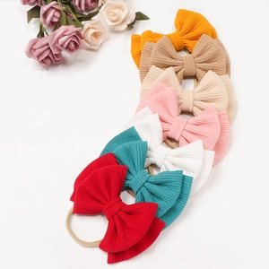 Set of 7 colorful ribbed oversized bow headbands for baby girls on white background