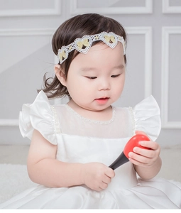 Détails du bandeau en dentelle brodée pour bébé avec nœud doré et col en perles