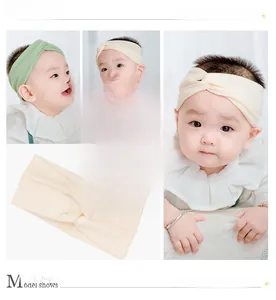 Detail of sweet knit criss-cross baby headbands in soft cream and pastel green tones