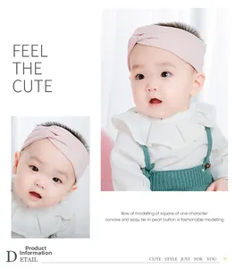 Pink ribbed cotton baby headband with twist knot detail on cute model showing fit
