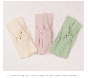 Close-up of knit cross-knot baby headbands in beige, pink, and green colors