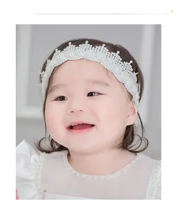 Detail of white baby lace crown headband with pearls for newborn photography