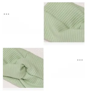 Close-up of the light green knitted baby headband with a soft cross-knot texture and stretch