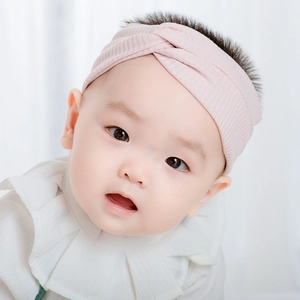 Sweet pink knitted twist headband for infants with elastic ribbed texture for soft fit