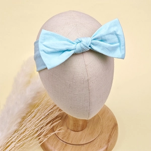 Gros plan d'un bandeau bébé bleu clair en coton avec nœud doux sur un support