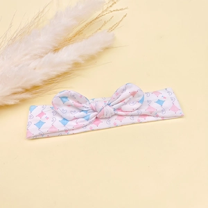 Gros plan détaillé d'un bandeau pour bébé blanc avec des motifs de cerf-volant et un nœud
