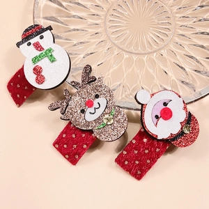 Trois barrettes de Noël avec paillettes, renne et Père Noël sur une plaque de verre
