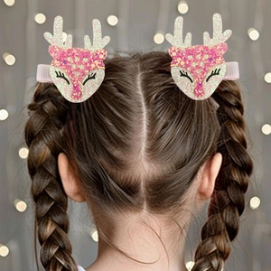 Détail de pinces à cheveux bois de renne pailletés rose portées par un enfant pour Noël