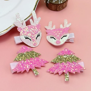 Vue détaillée des barrettes de Noël à paillettes cerf et sapin sur un plateau doré