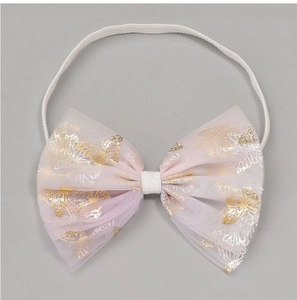 Détail du bandeau bébé avec nœud en maille rose, imprimé papillon doré et élastique