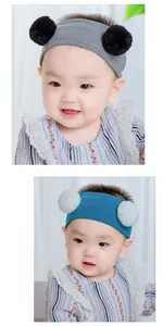 Details von Baby-Strickstirnbändern mit Pompons in Grau und Blau an einem Kleinkind