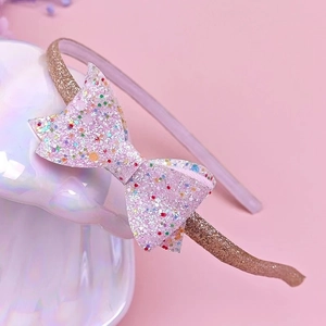 Dettaglio del cerchietto rosa con paillettes per bambina con fiocco scintillante e colorato