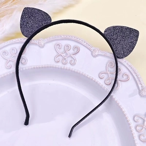 Detailed view of black sequined cat ears headband on a white decorative porcelain plate