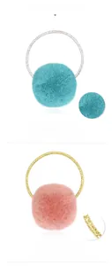Nahaufnahme weicher blauer und rosa Strick-Pompon-Haargummis mit glitzerndem Elastikband