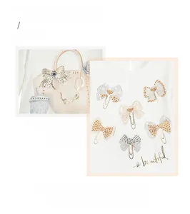 Detail showing white girl's top with silver glitter bowknot and handbag print patterns
