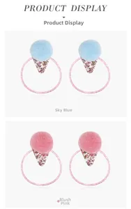 Close-up of fluffy pom pom hair ties with star sequins in sky blue and blush pink colors