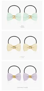 Detail of fabric bow hair ties in mint green, champagne gold, and lavender purple with gold buckle